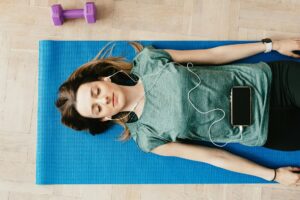 How Celebrity Meditation Apps Are Competing With Traditional Streaming Services Person using smartphone for meditation with headphones in peaceful setting