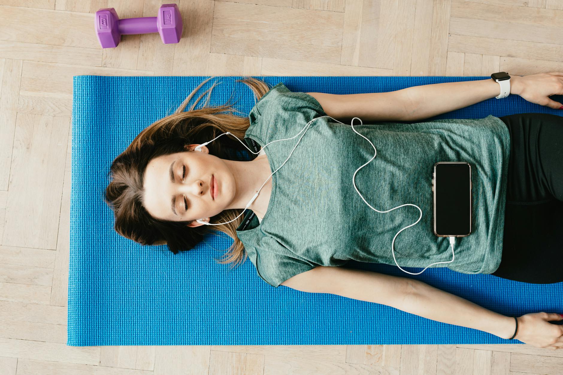 Person using smartphone for meditation with headphones in peaceful setting