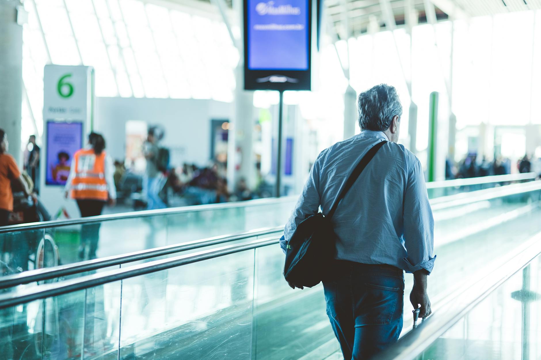 Modern airport terminal with travelers walking through, showcasing contemporary travel fashion and style
