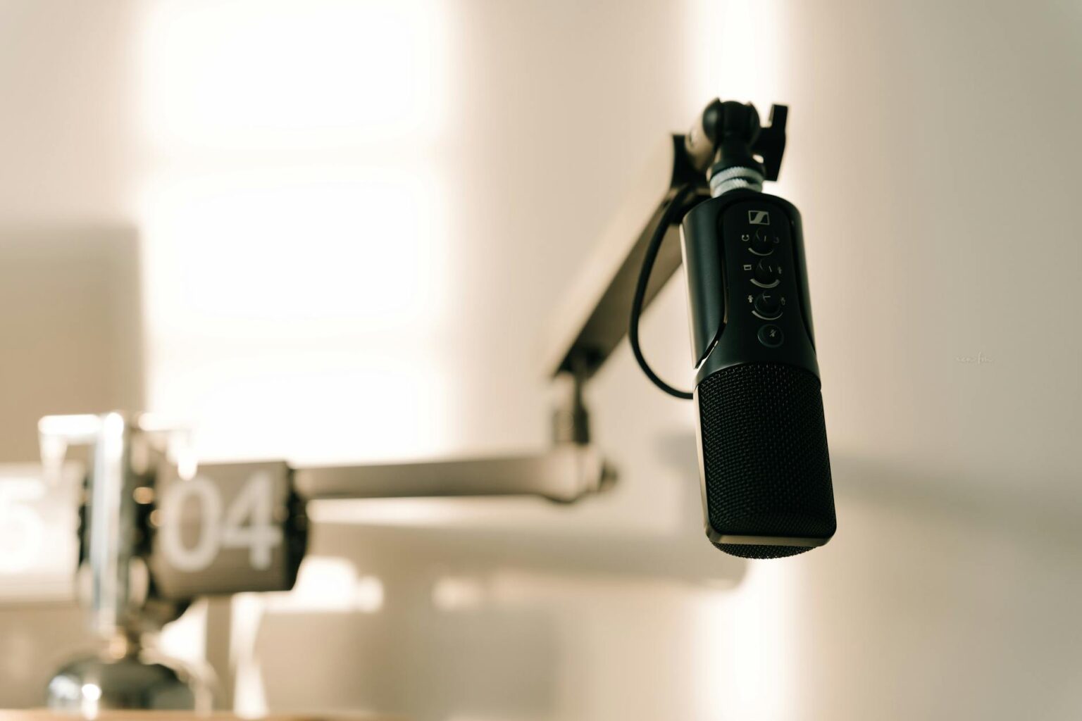 Professional radio microphone in broadcasting studio with equipment in background
