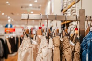 The Unexpected Thrift Store Chains Influencers Are Making Trendy Organized clothing racks in a bright retail store showing various garments hanging neatly