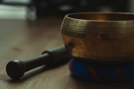 Close-up of Tibetan singing bowls and meditation cushions in a peaceful wellness studio setting