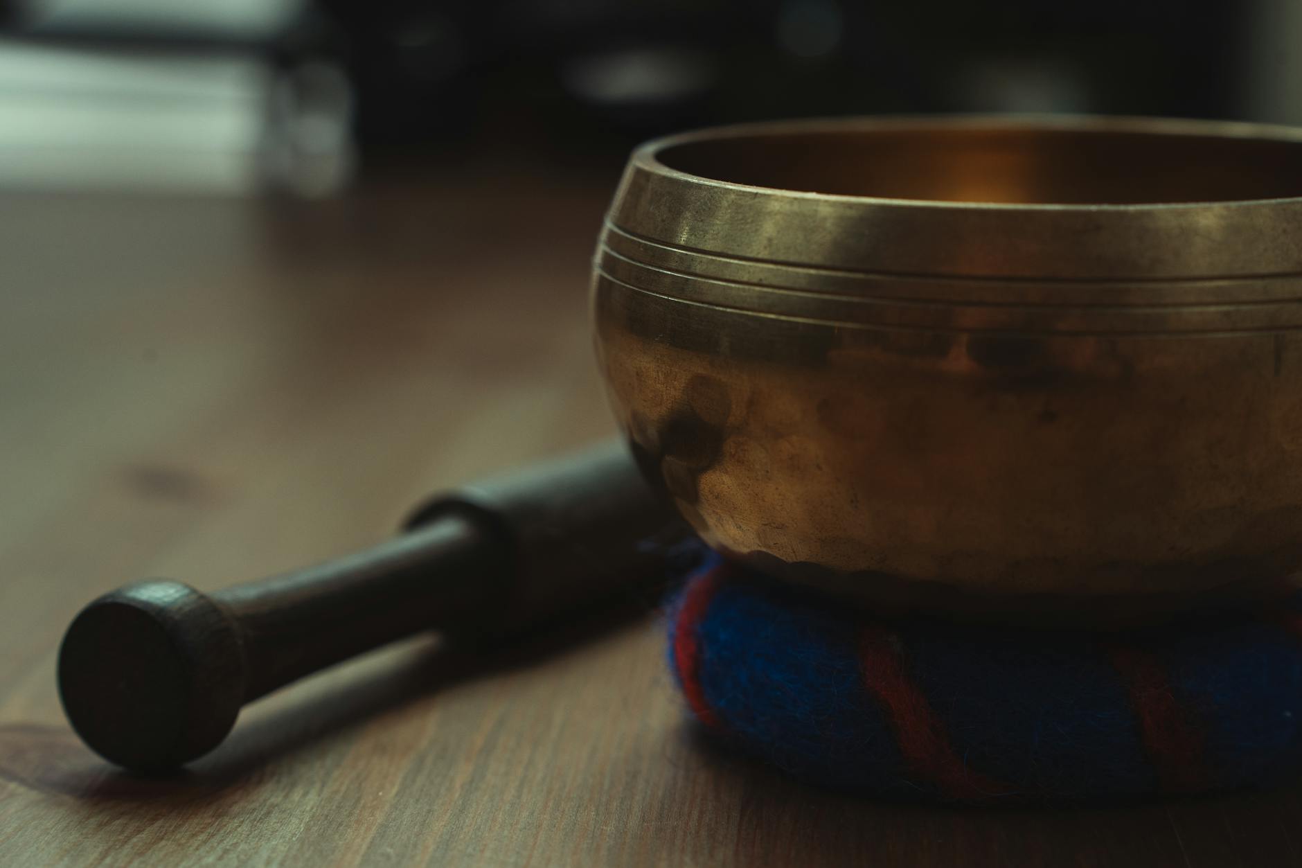Close-up of Tibetan singing bowls and meditation cushions in a peaceful wellness studio setting