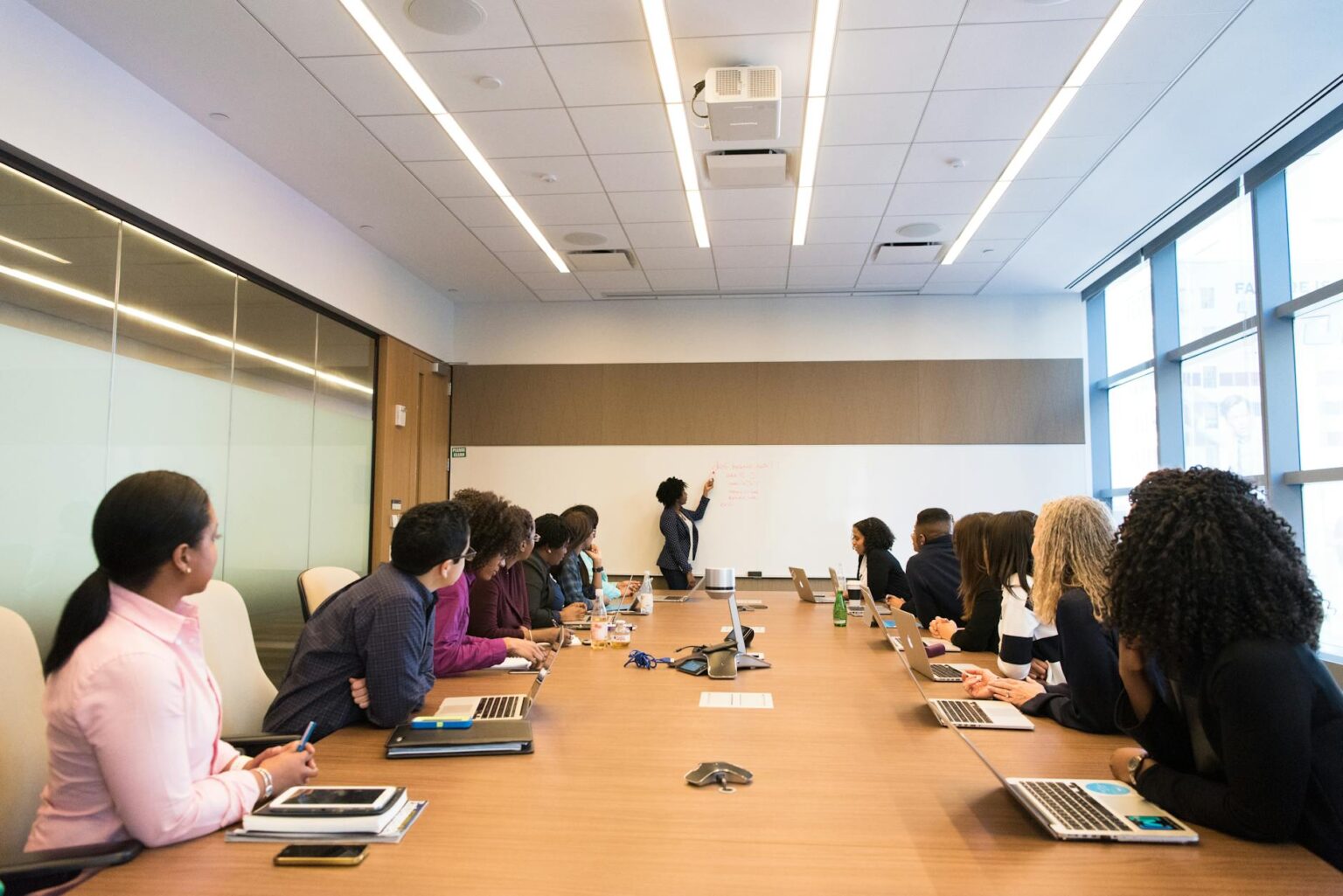 Professional conference room with papers and documents scattered on wooden table during business meeting