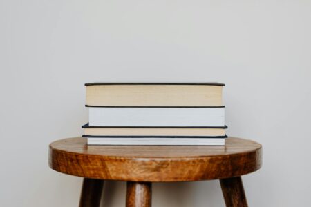 Stack of books arranged on a wooden table surface