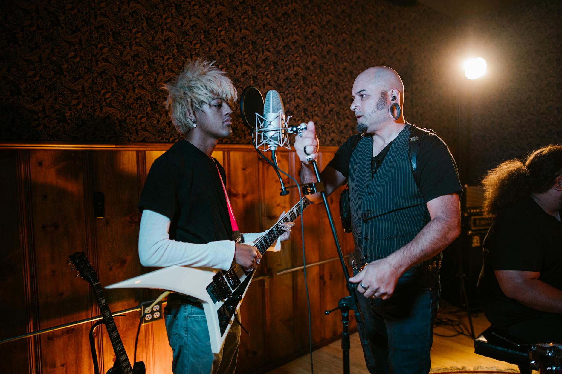 Musicians recording in a professional studio with instruments and equipment