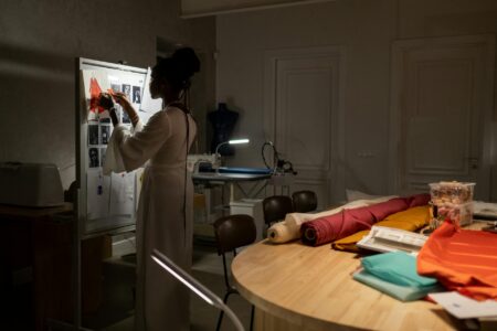 The Unexpected Designer Behind Hollywood’s Most Talked About Looks Fashion design studio workspace with sketches, fabrics, and design tools