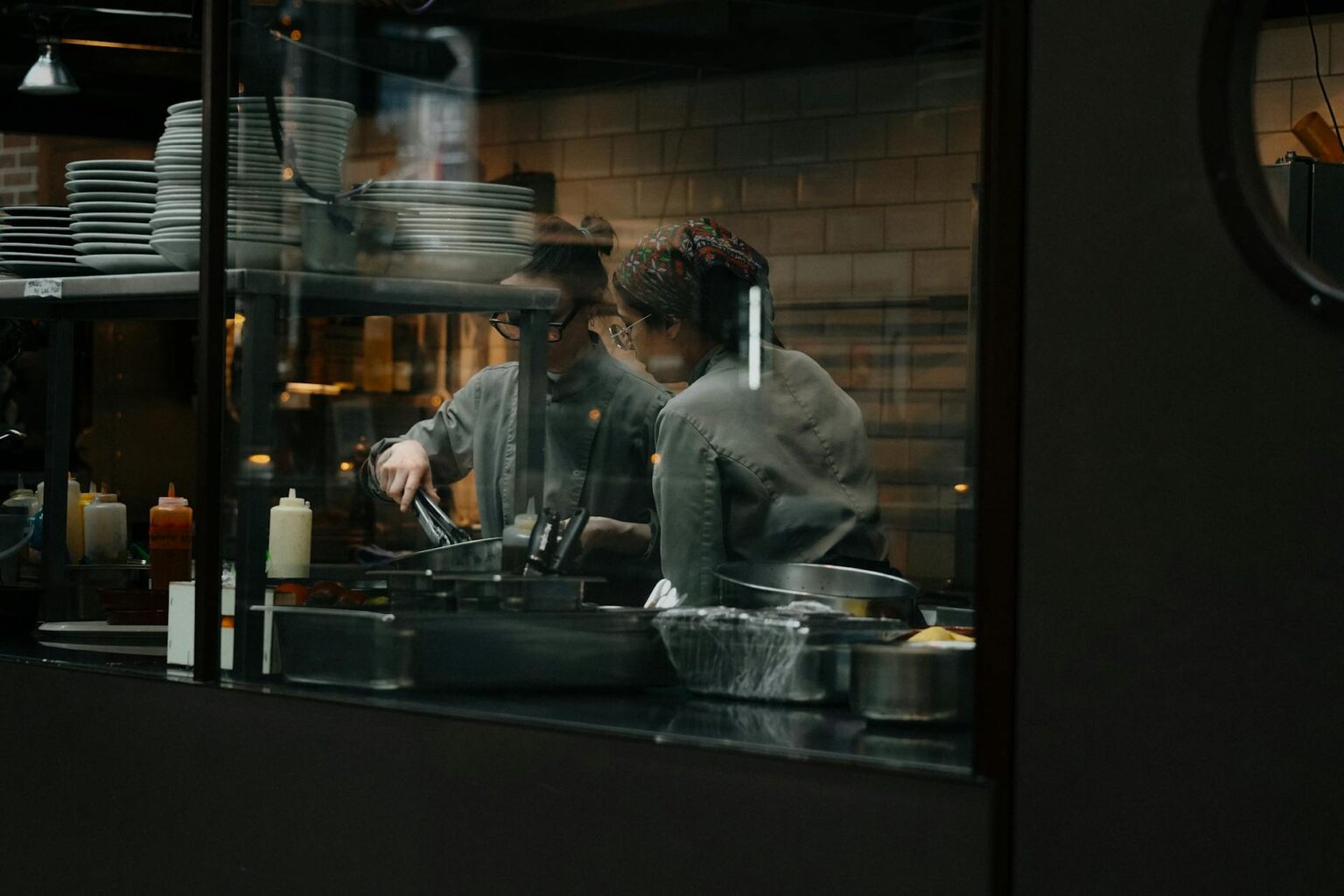 Modern restaurant kitchen with chefs working at cooking stations