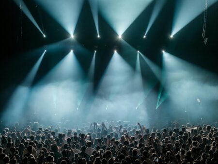 How Live Concert Streaming Is Creating New Revenue Models Professional concert stage with colorful lighting equipment and empty venue seating