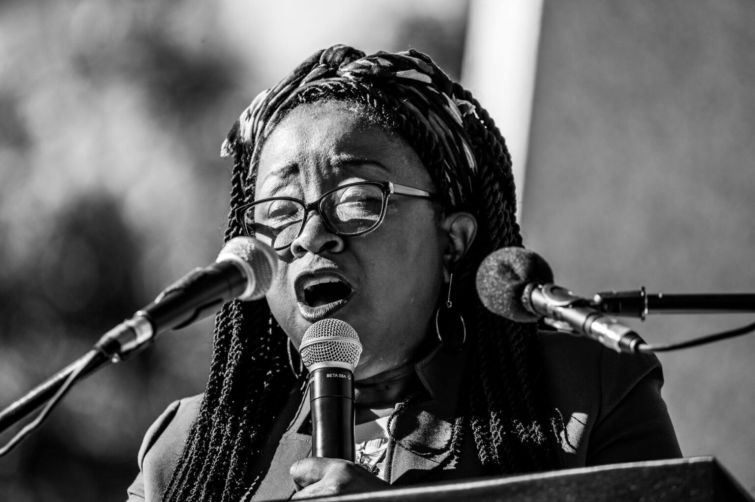 Professional woman speaking into microphone at media event