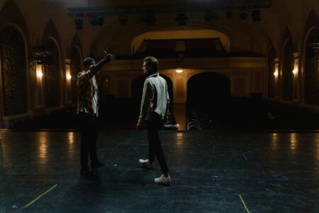 Broadway theater stage illuminated with professional lighting system and empty red velvet seats