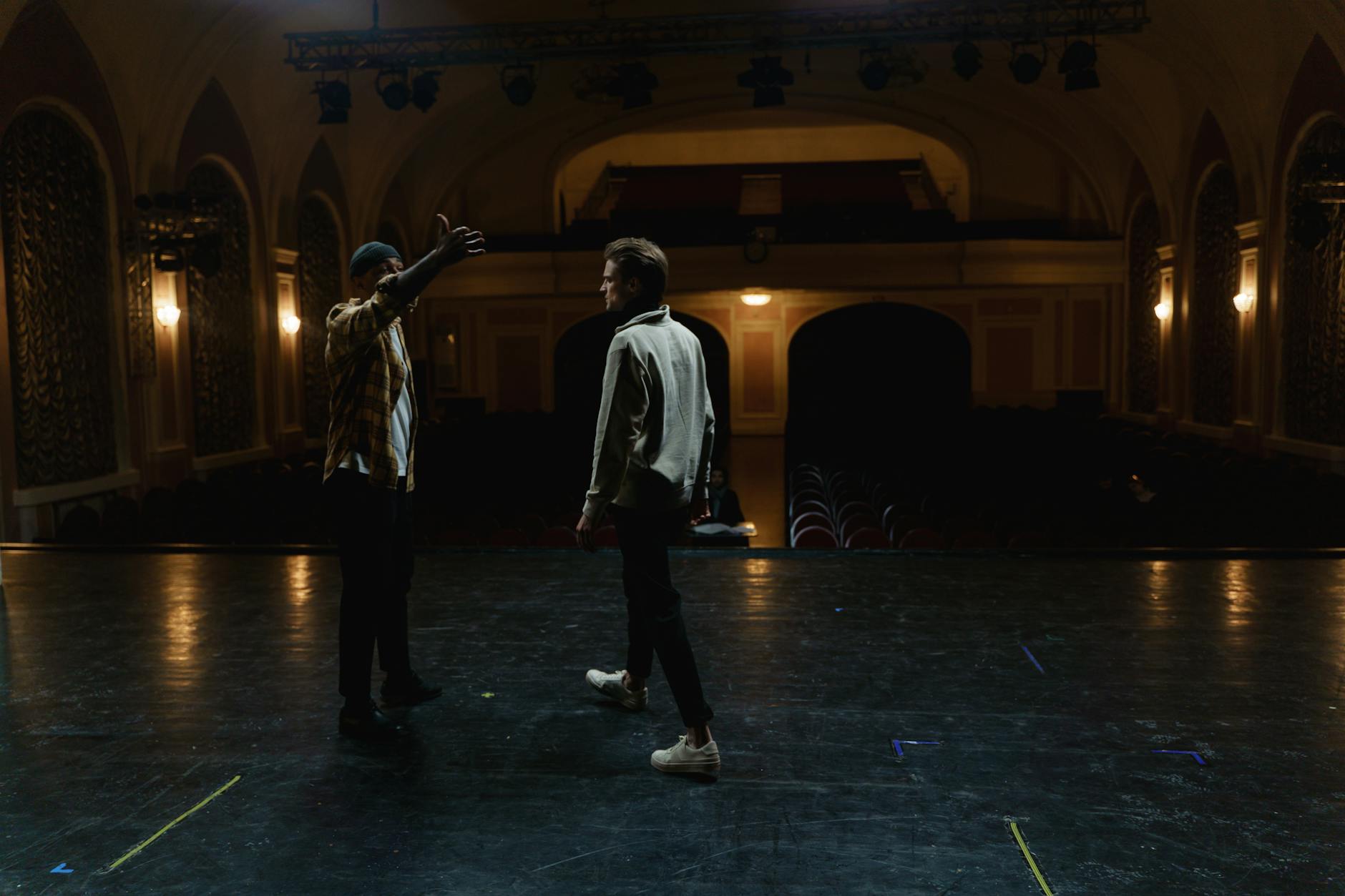 Broadway theater stage illuminated with professional lighting system and empty red velvet seats
