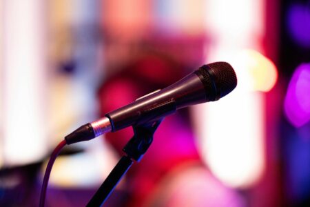 Professional microphone on stage with dramatic lighting for live comedy performance