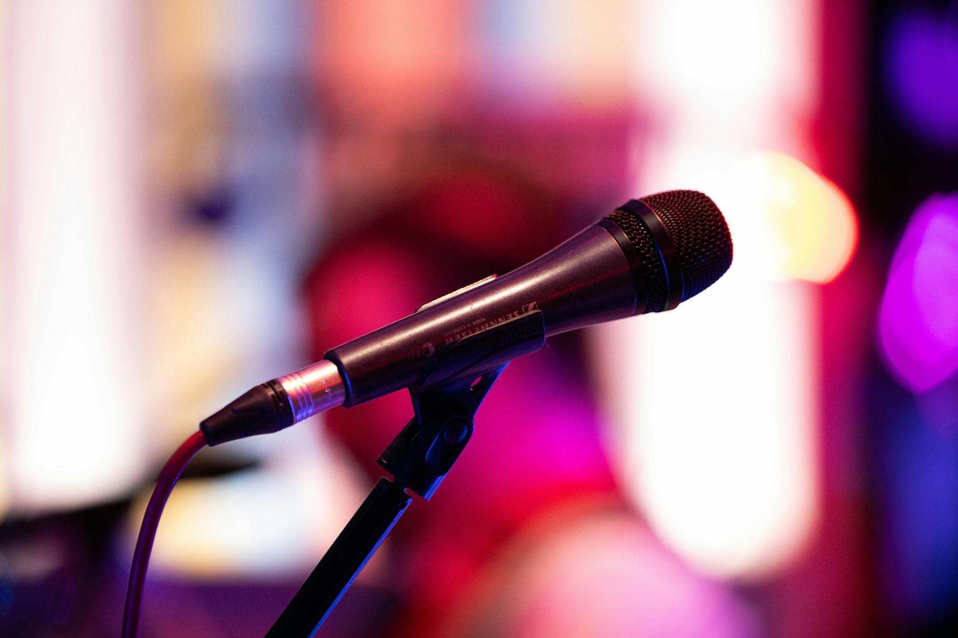 Professional microphone on stage with dramatic lighting for live comedy performance