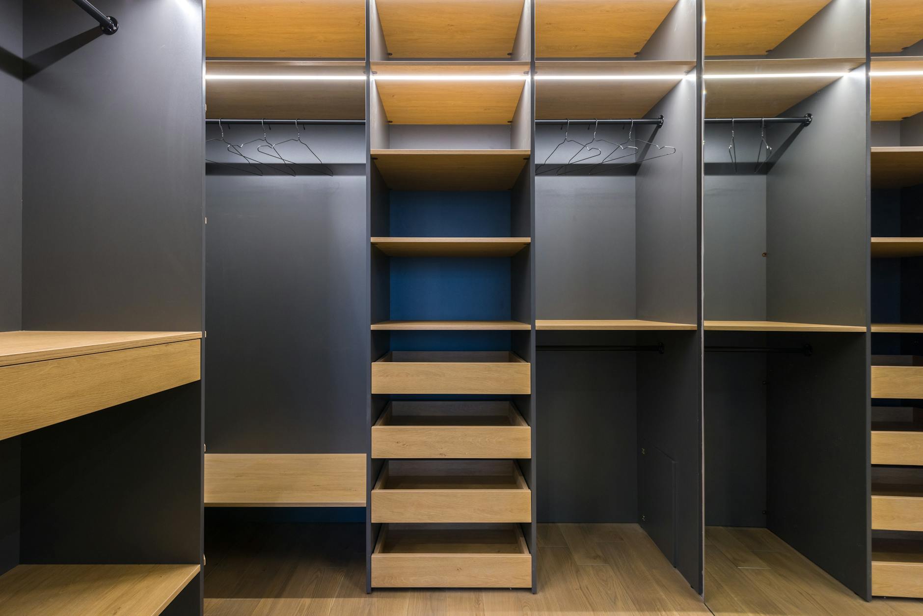Organized luxury walk-in closet with designer clothing and accessories neatly arranged