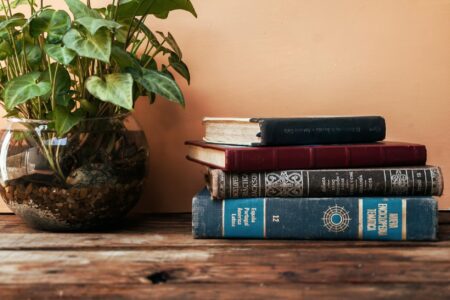 Stack of books on wooden table representing book club selections