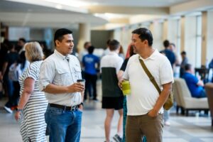 Why Millionaires Are Hiring Professional Conversation Coaches for Social Events Professional networking event with people in business attire having conversations