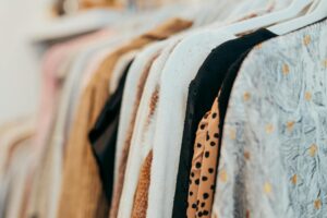 Designer clothing hanging on a retail rack in an upscale store environment