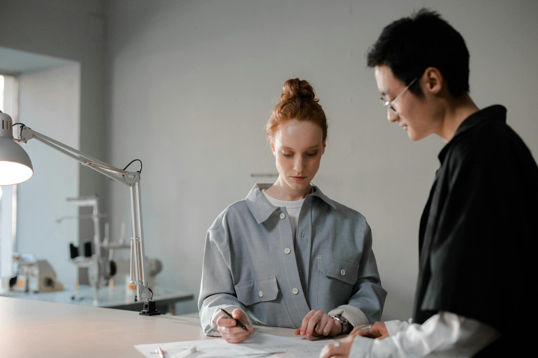 Fashion designer workspace with sketches, fabric samples, and vintage clothing pieces for inspiration