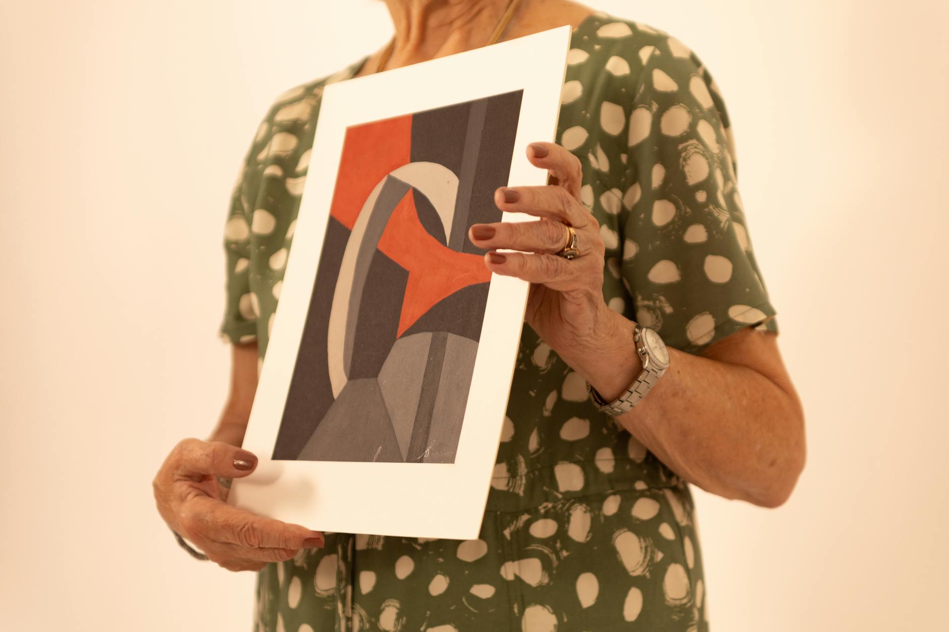 Professional portrait of a young person examining artwork in a gallery setting