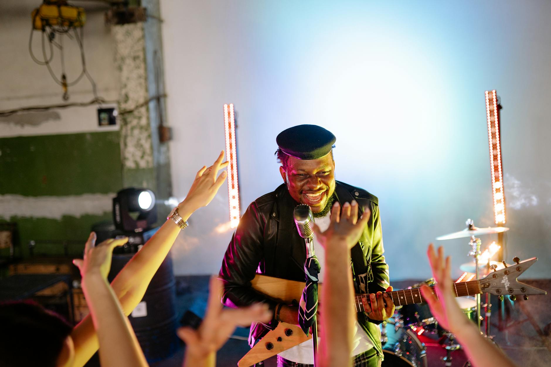 Performers on stage during a live music concert with atmospheric lighting
