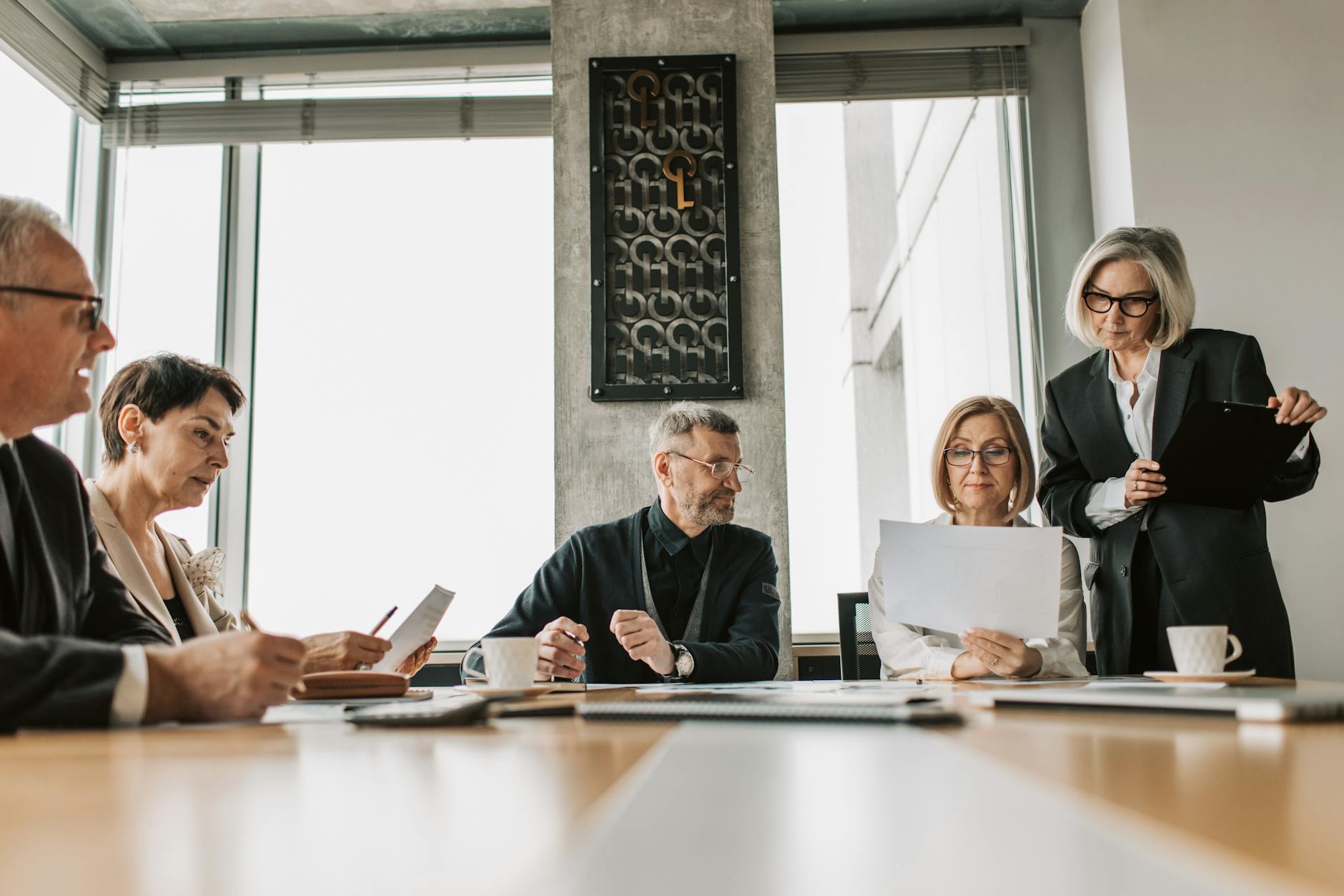 Business professionals in meeting discussing strategy and contracts at conference table