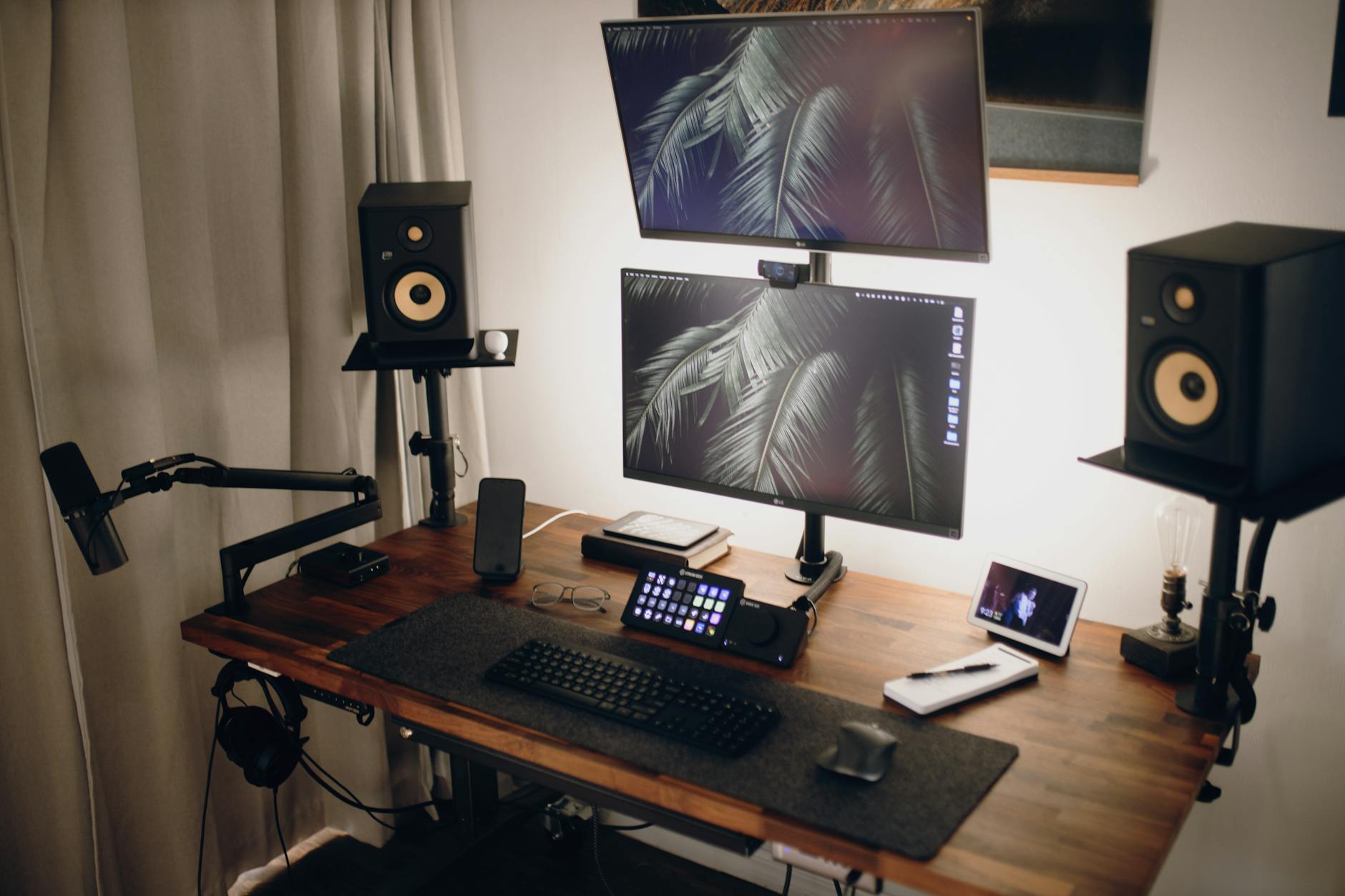 Modern computer setup with multiple monitors displaying streaming software and audio equipment