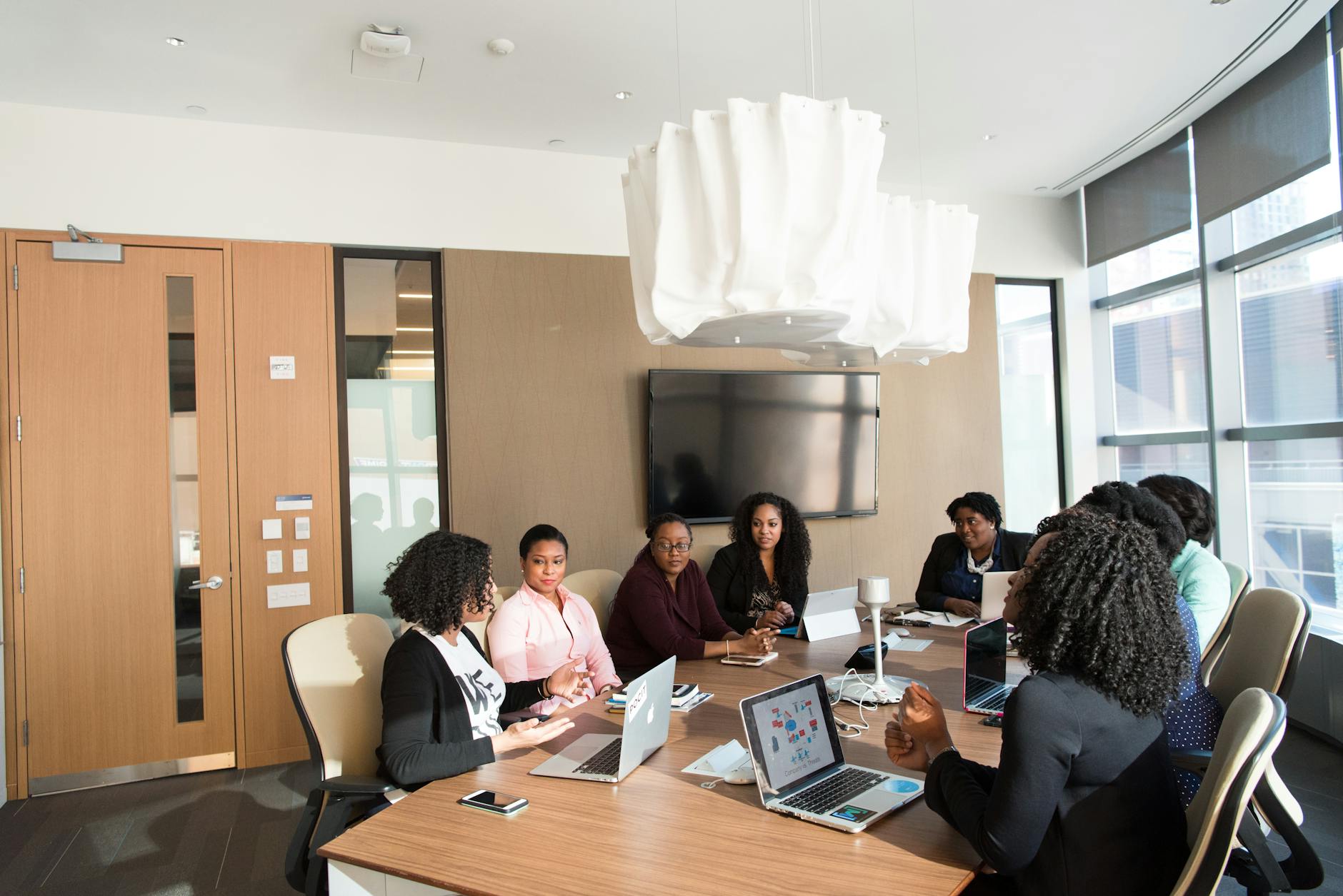 Business professionals discussing documents around conference table