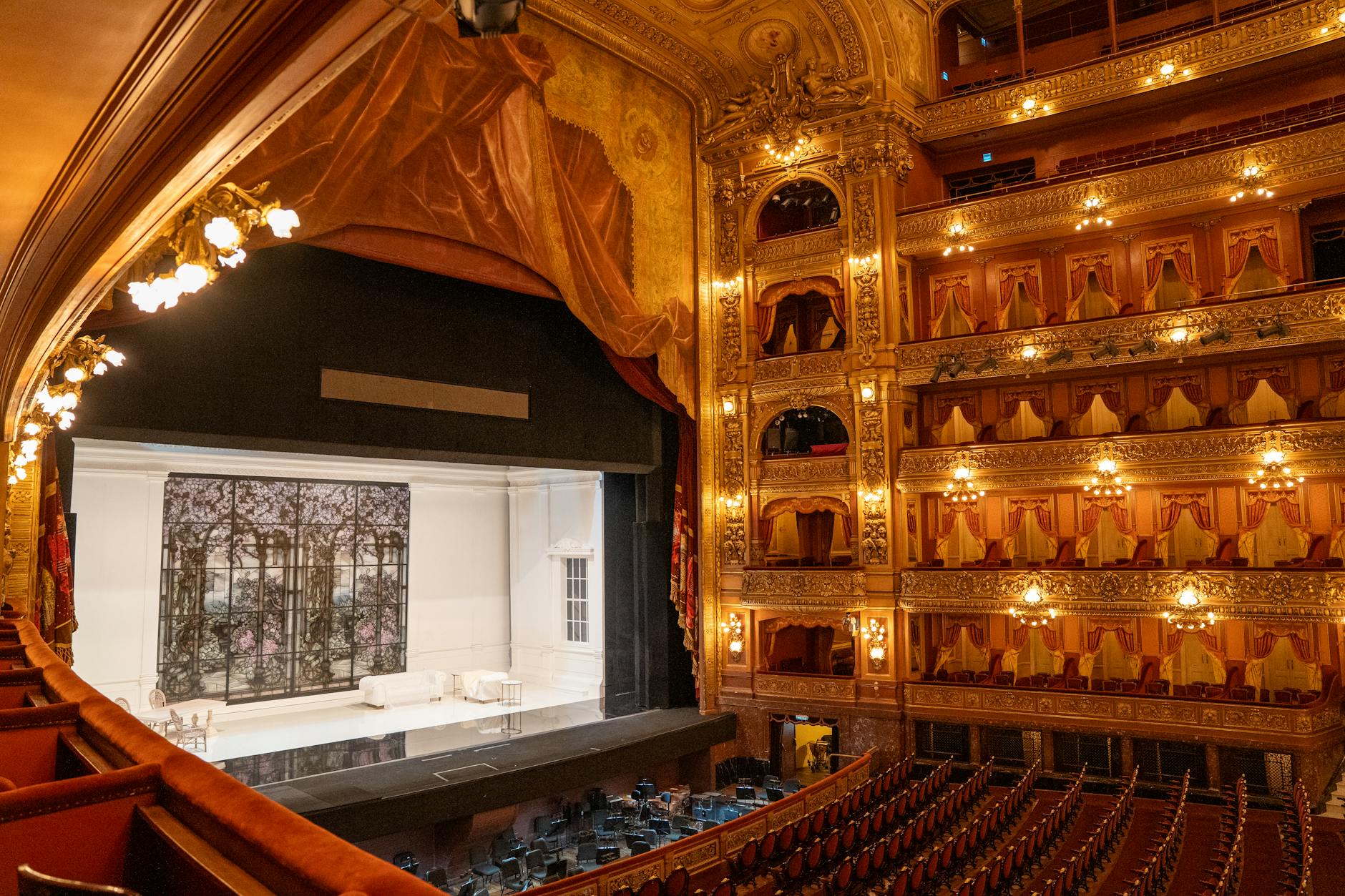 Broadway theater stage with dramatic lighting setup and empty seats showing the performance space