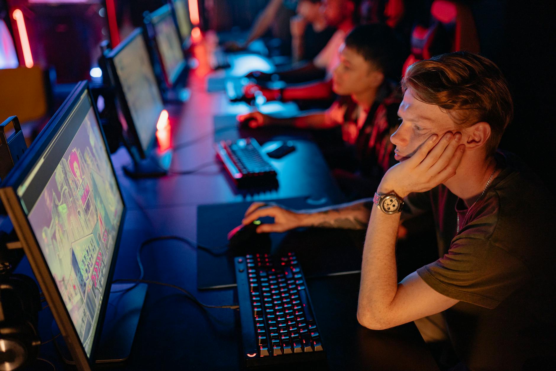 Competitive gaming tournament with players seated at gaming stations under professional lighting
