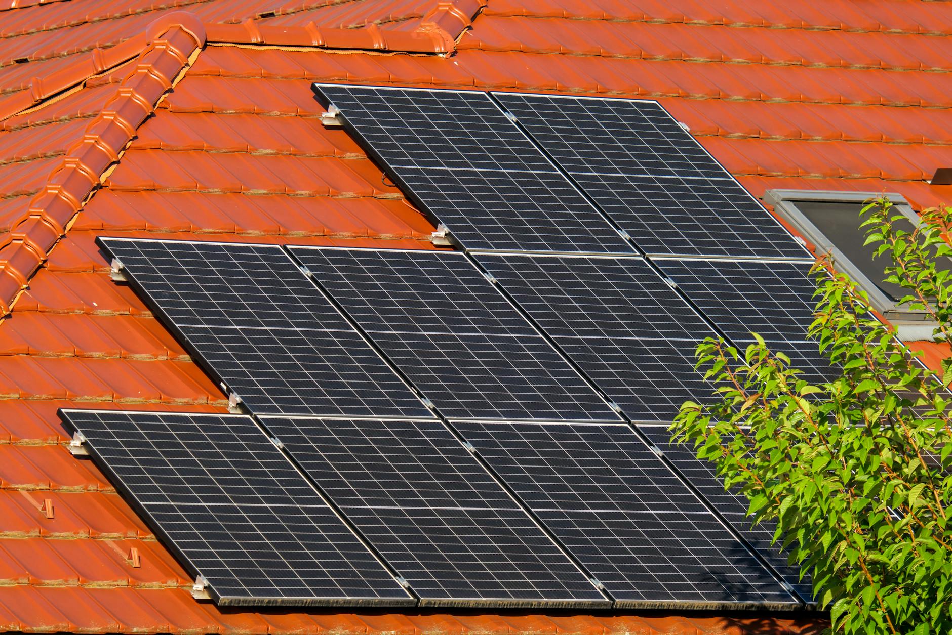 Modern solar panel installation on residential rooftop against blue sky