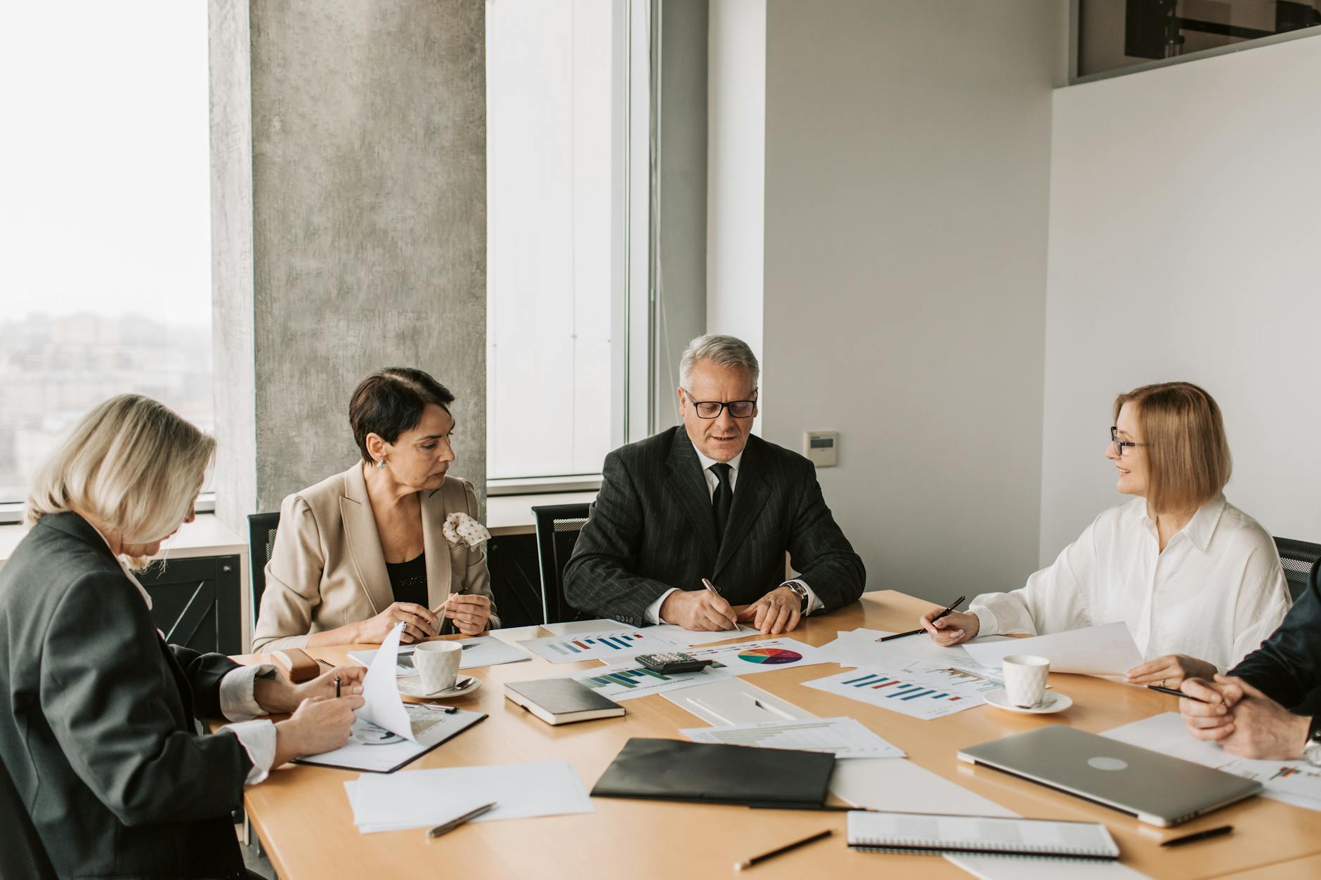 Professional business meeting with documents and laptops on conference table