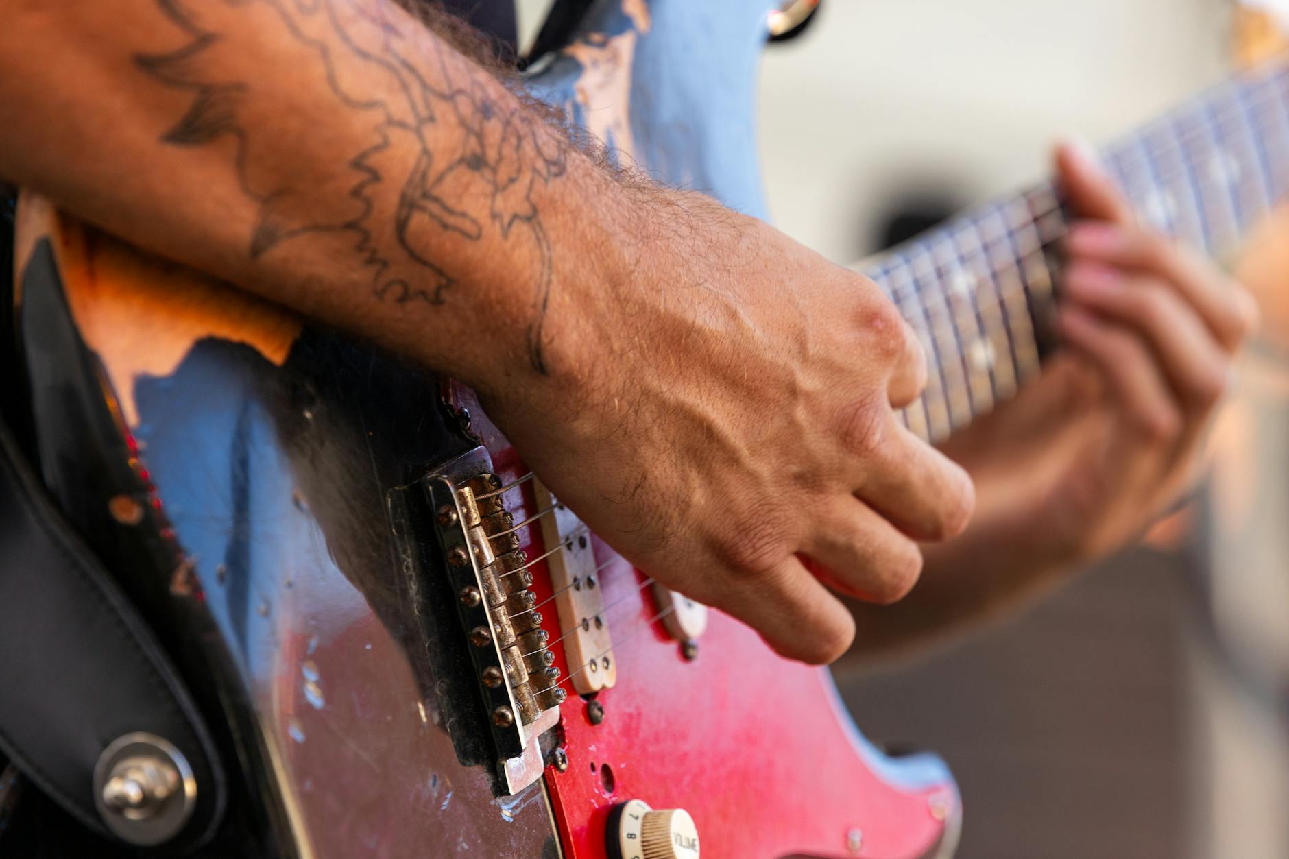 Musician playing acoustic guitar in intimate setting with warm lighting