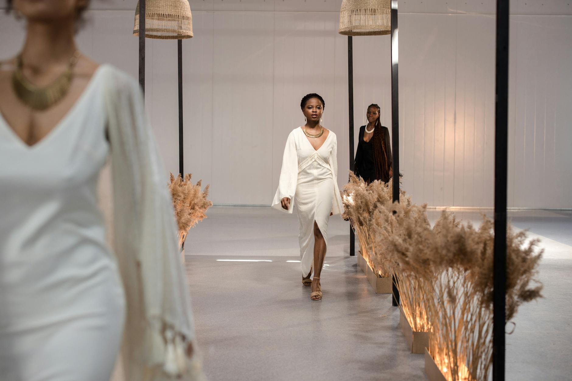 Models walking runway at high-end fashion show with audience