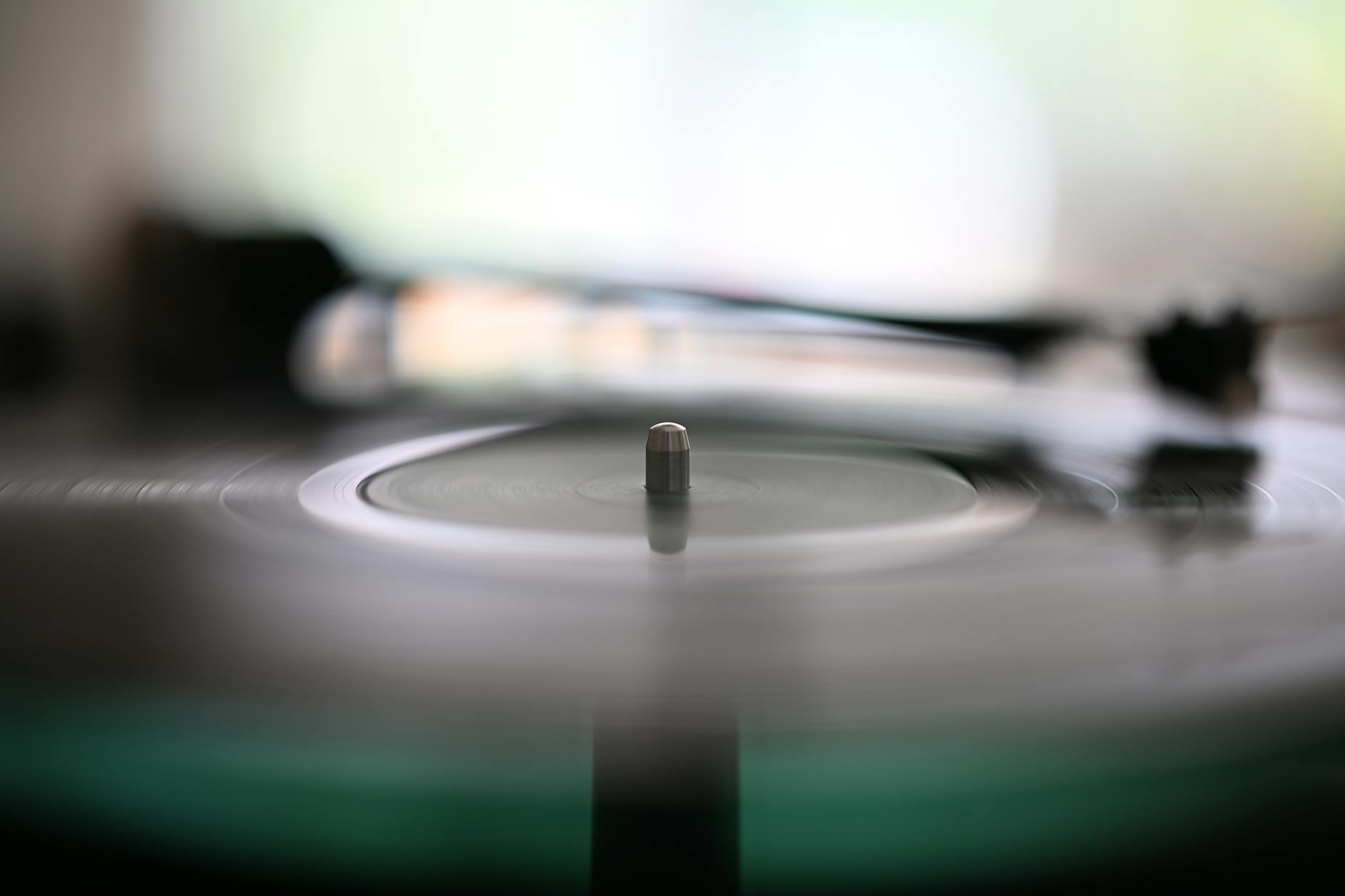 Close-up of a turntable with a vinyl record spinning, representing the vinyl listening experience