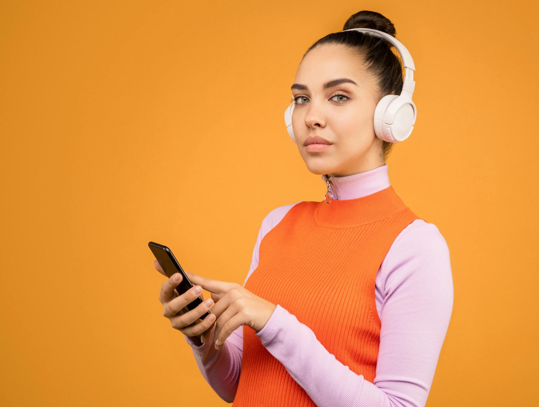 Person listening to podcasts on smartphone with headphones, representing audience engagement