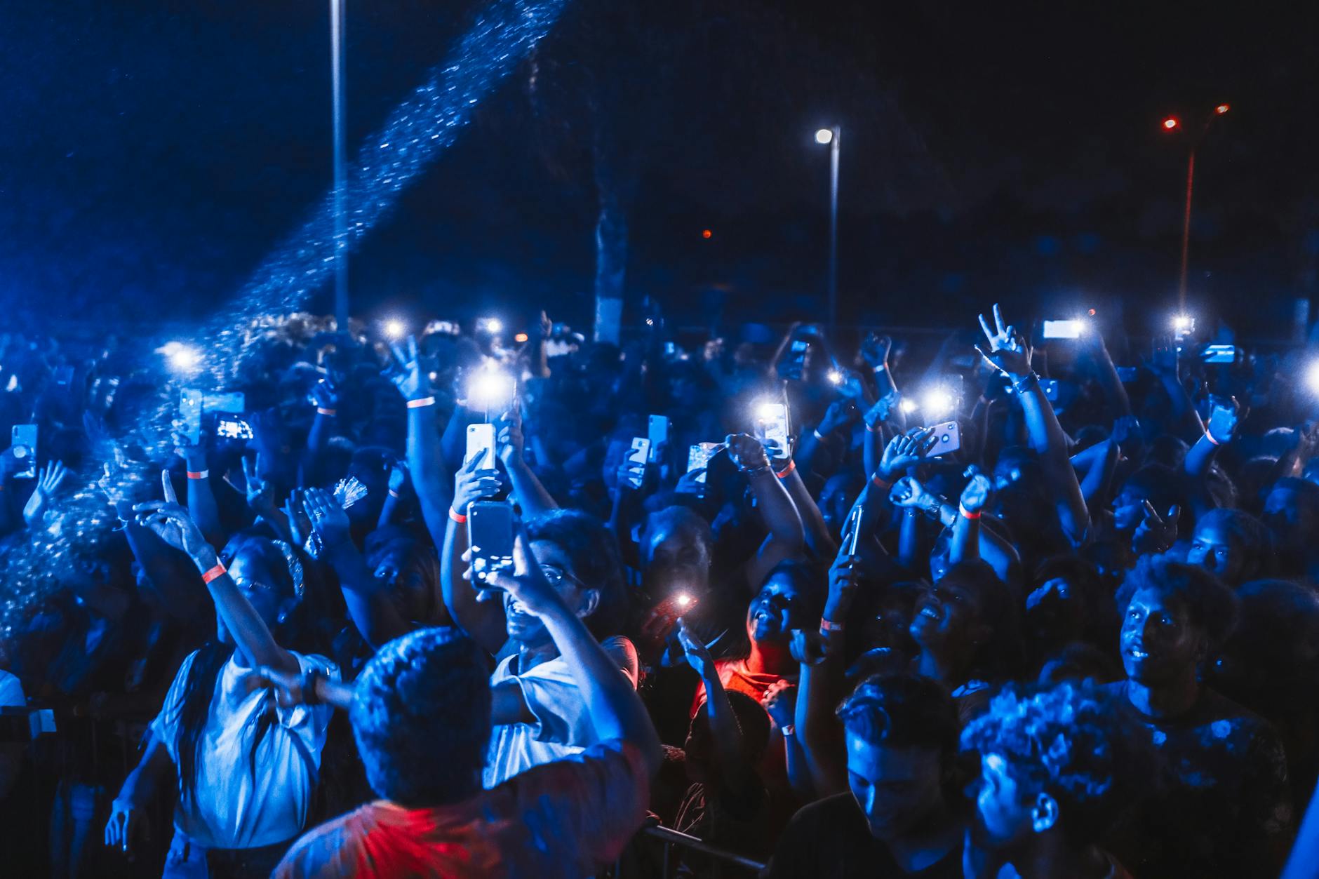 Theater audience members holding up mobile devices during live performance