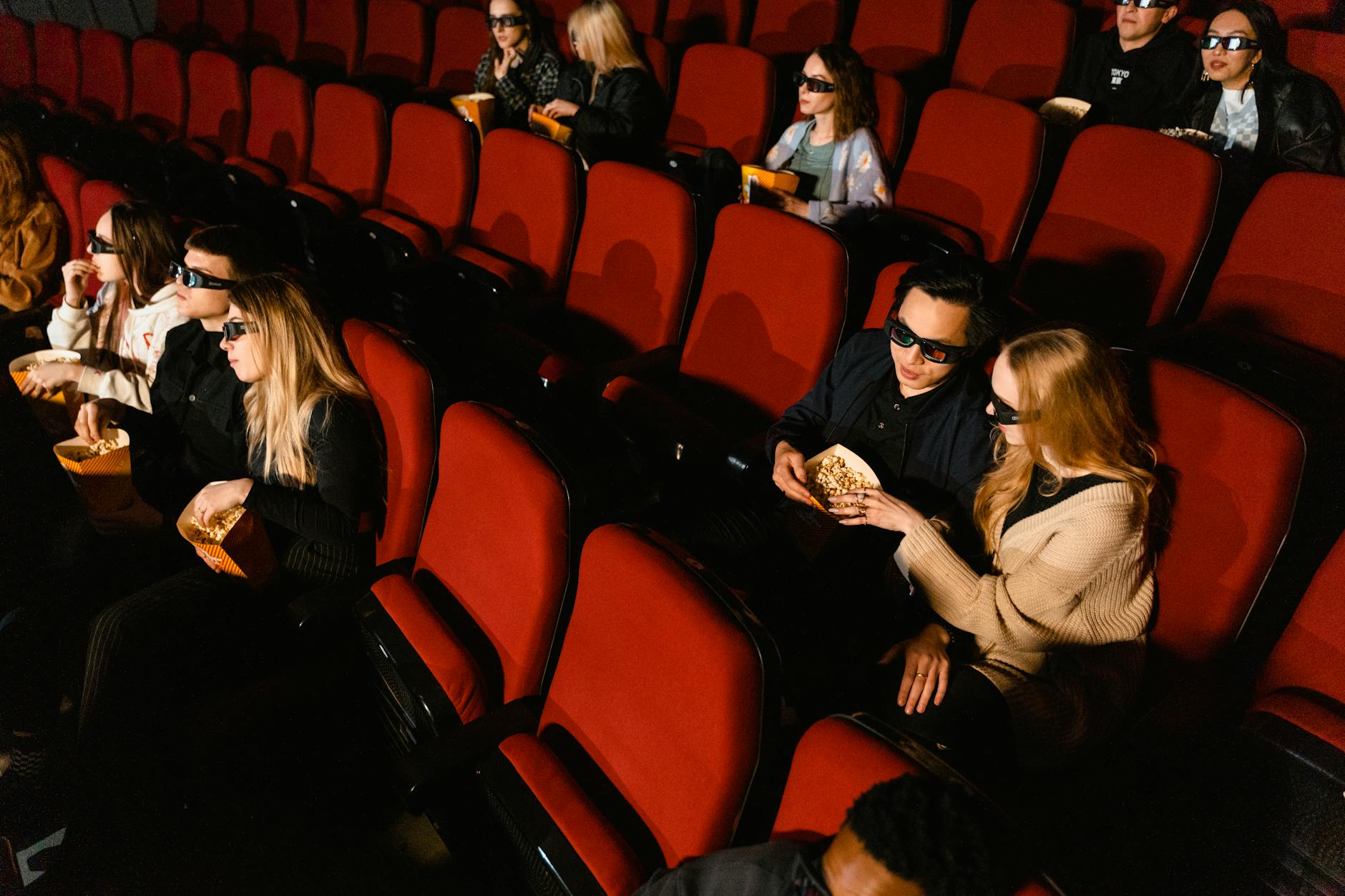 Empty movie theater with red seats and projection screen