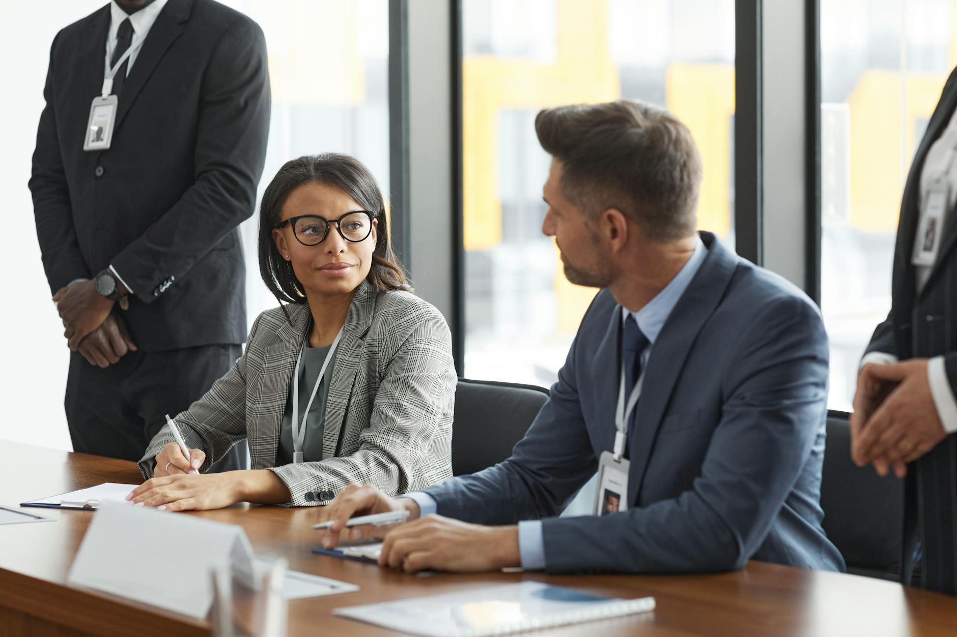 Business professionals having discussion at conference table in modern office setting