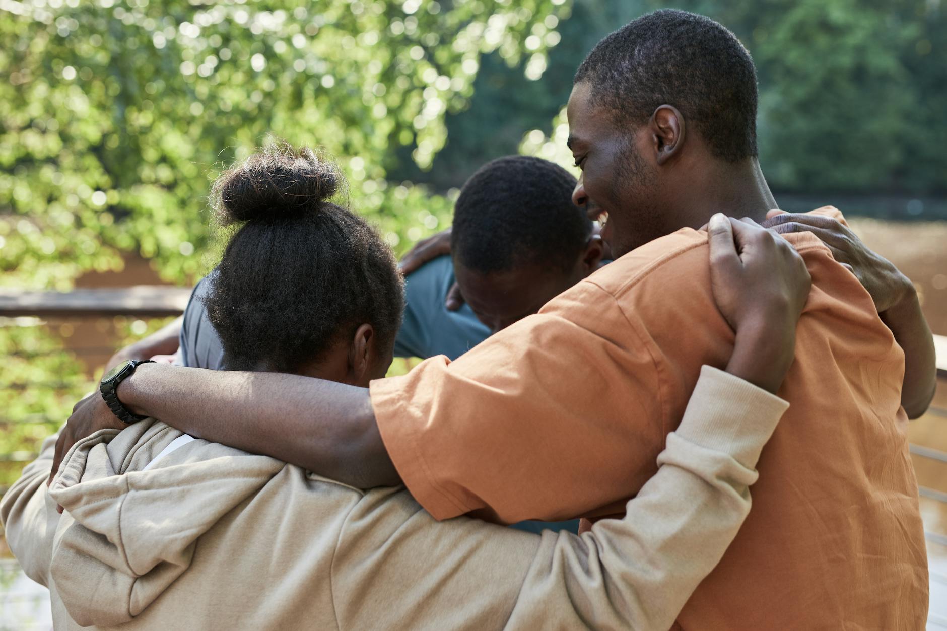 Diverse group of young adults sitting in circle during peer support group meeting