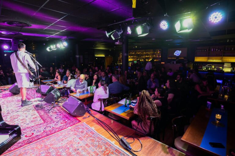 Comedy Clubs Are Converting to Podcast Recording Studios Interior of a comedy club with stage, microphone, and intimate seating arrangement