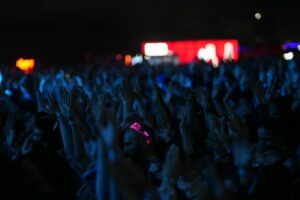 Chappell Roan’s Grassroots Fanbase Is Pressuring Major Label Deals Large crowd at a nighttime music concert with stage lights overhead