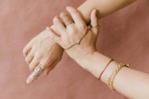 Cartier’s Love Bracelet Is Losing Ground to Signet Rings Stacked gold bracelets and rings displayed on a neutral surface
