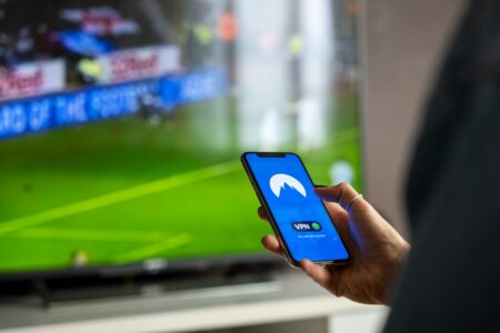 Netflix’s Password Crackdown Is Driving Users to Free Streaming Apps Person using TV remote to browse streaming content on television screen