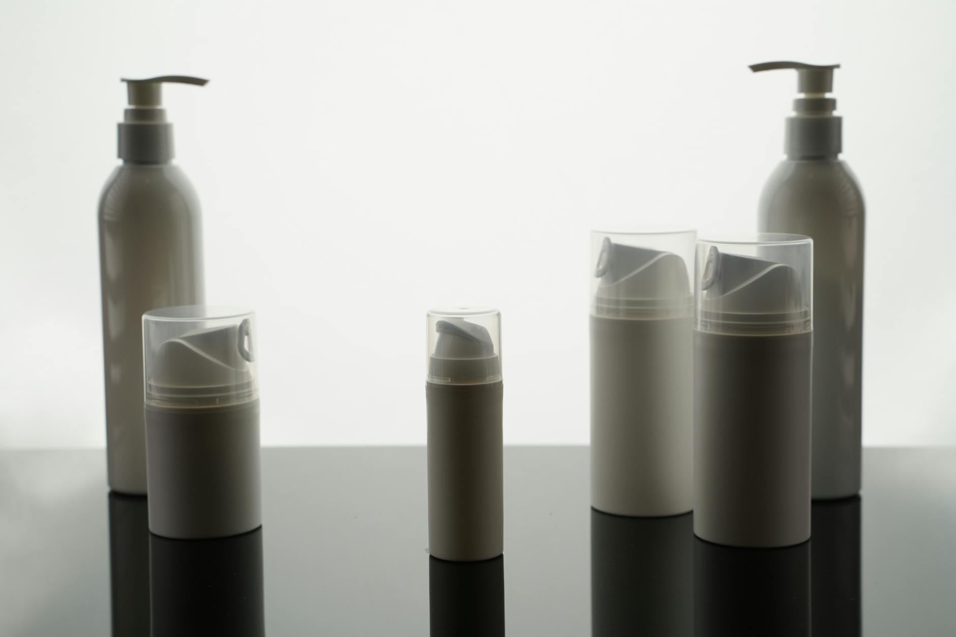 Clean white skincare product bottles arranged on minimalist background