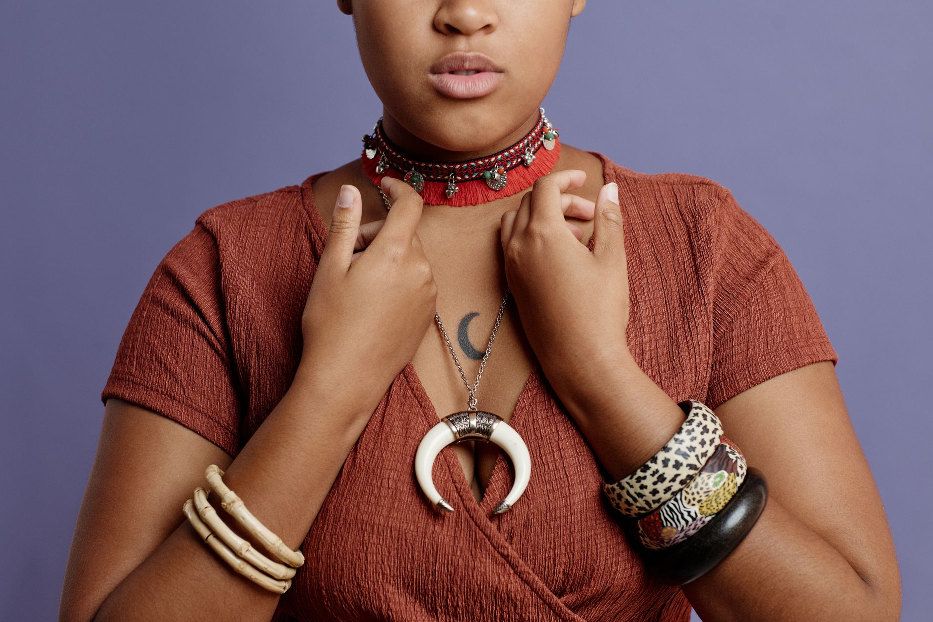 Close-up of layered statement necklaces and stacked rings as maximalist accessories