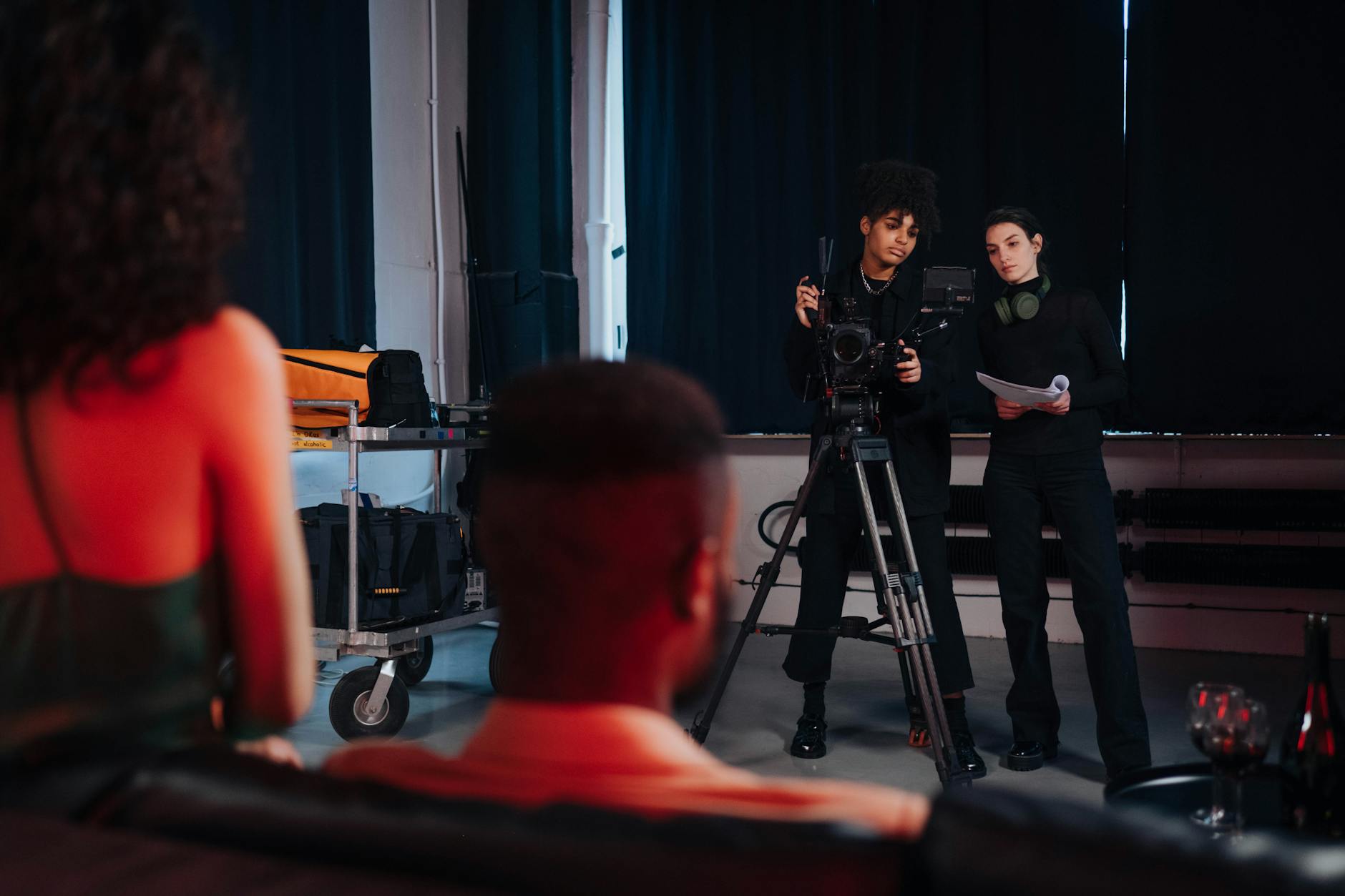 Woman sitting in director's chair on film set reviewing production materials