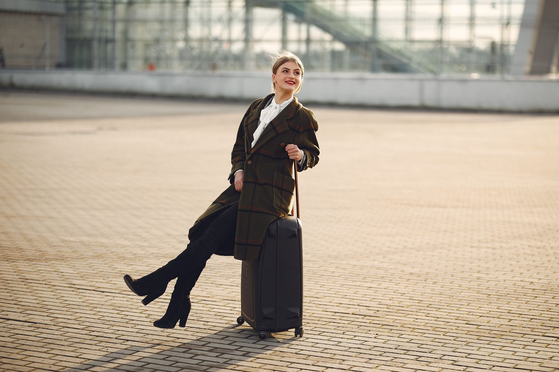 Well-dressed person in casual luxury clothing walking through an airport terminal