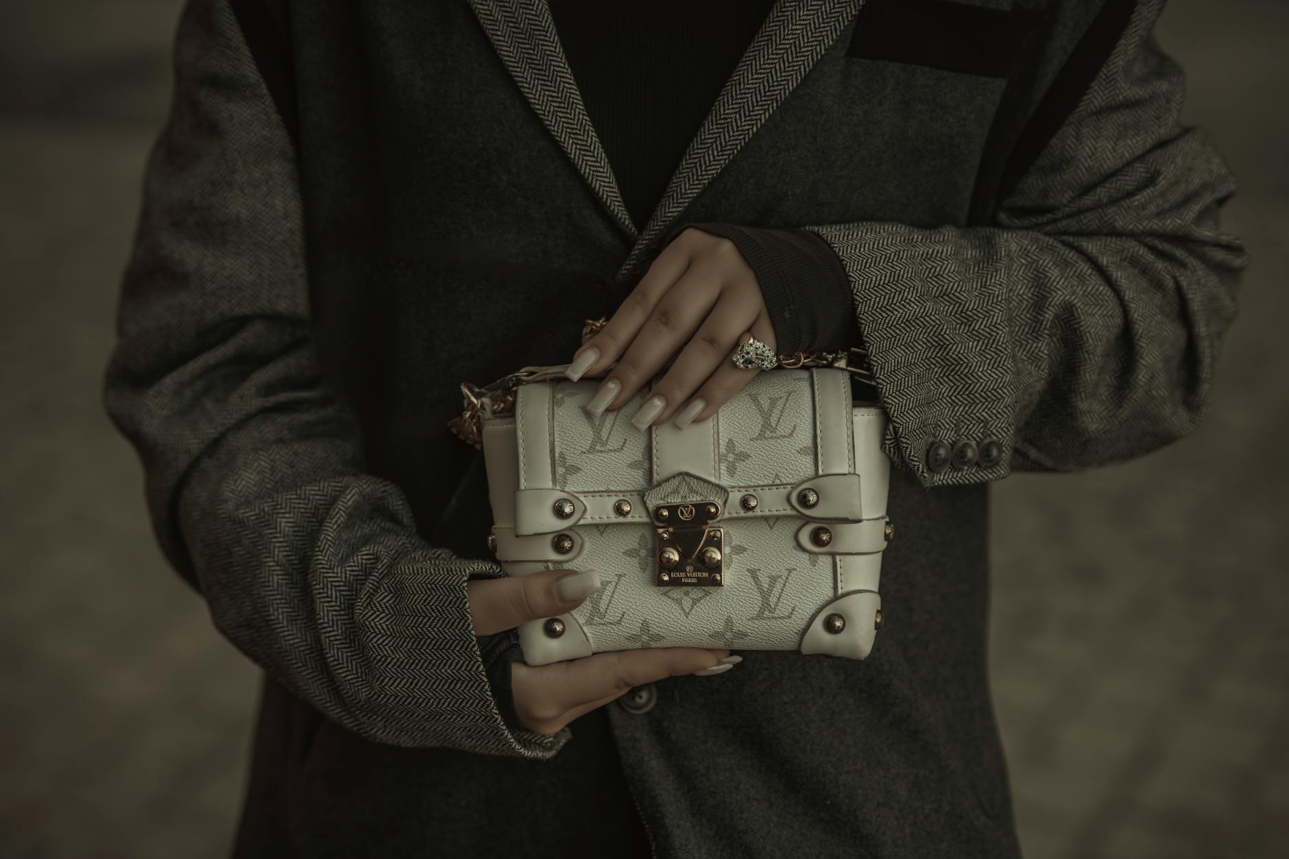 Stylish woman carrying a structured leather shoulder bag at a fashion event
