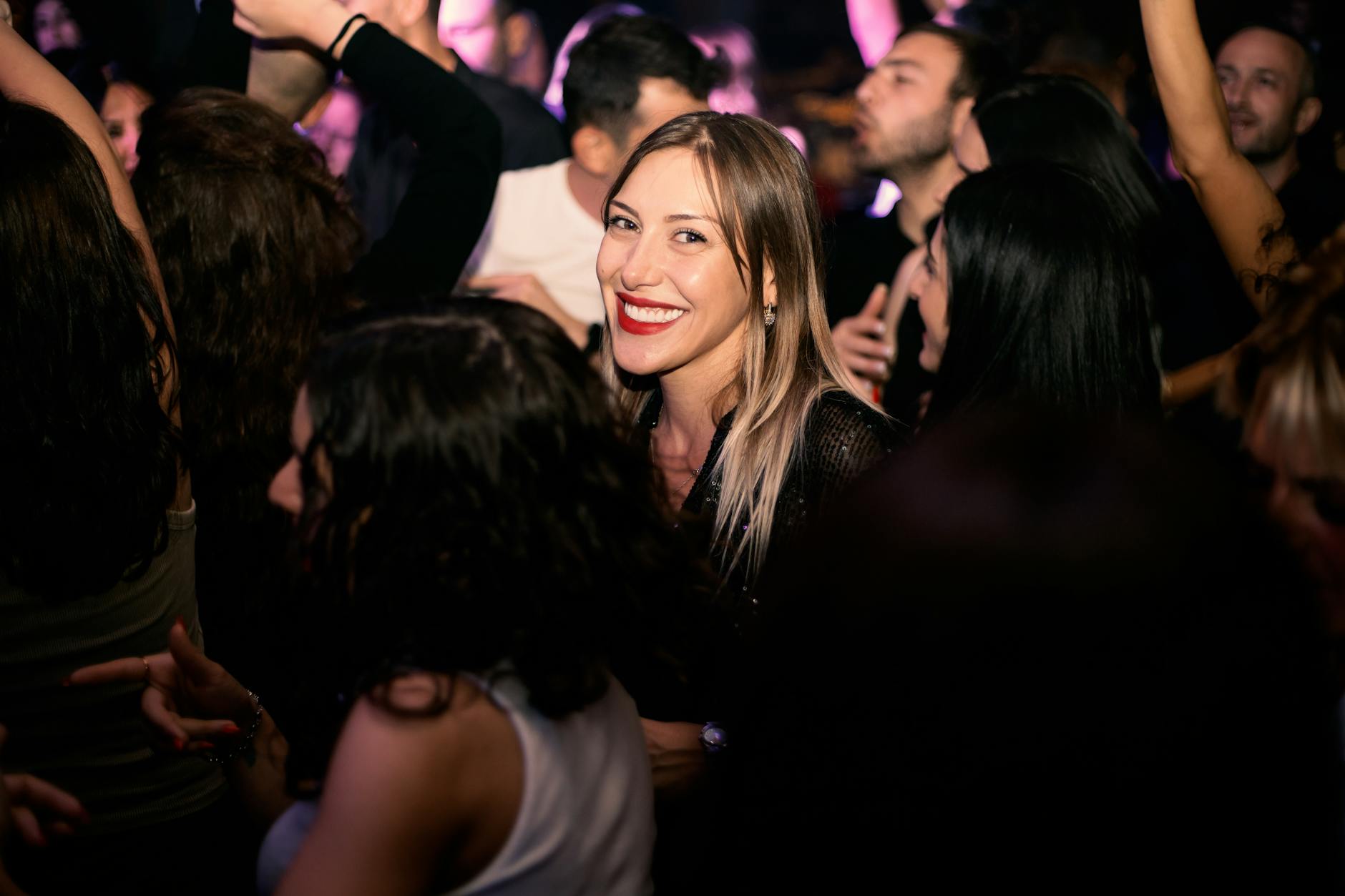 Young crowd gathered at an indoor festival event with stage lighting